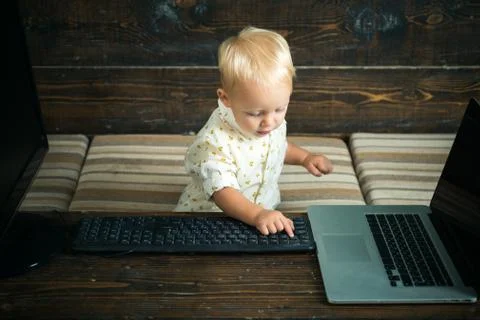 Child hacker type computer keyboard in office. Little computer hacker at work Stock Photos