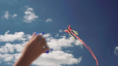 Child hand controls kite on clear summer day. Perfect blue sky and clouds Stock Footage 140824429