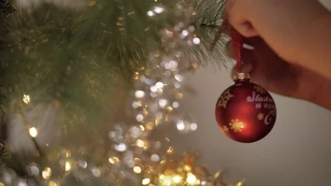 Child hand decorating on Christmas tree with glow lighting in background Stock Footage 81659780