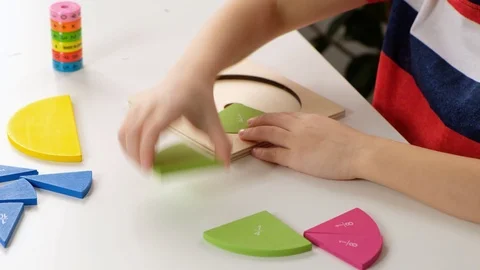 Child hand doing simple math exercises with fractions on white table, close up Stock Footage 125039121
