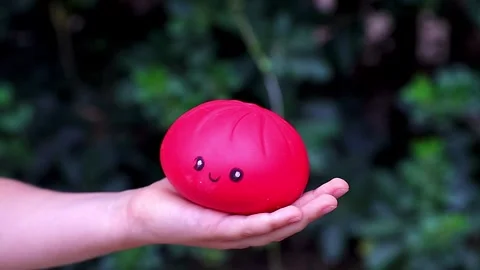Child hand holding pink translucent antistress squishy toy in bear shape out Stock Footage 344582944