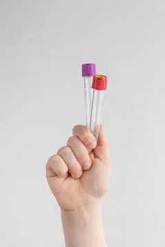 Child hand holding two test tubes. white and gray background with copy space. Stock Photos