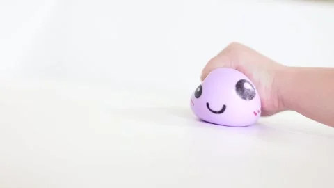 Child hand squeezing purple smiling dumpling squishy Stock Footage 334434226