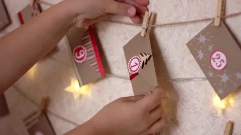 Child hand take off the daily envelope from a Christmas holiday advent calendar Stock Footage 165816080