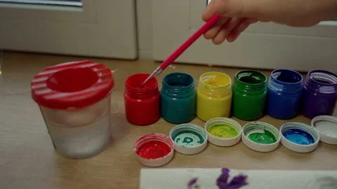 Child hand take paint on brush. Female person using imagination Stock Footage 166151359