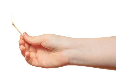 A child hand with a thin burning match on a white background. Stock Photos