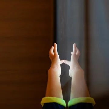 Child hand touching an illuminated interactive surface with reflection repr.. Stock Photos