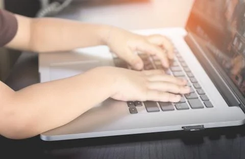 Child hand is working on computer keyboard Stock Photos