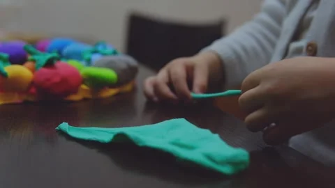 Child hands creating Easter eggs from play dough Stock Footage 285268694
