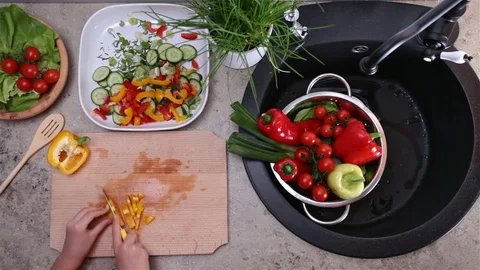 Child hands cutting a bellpepper for a vegetables salad Stock Footage 79991978