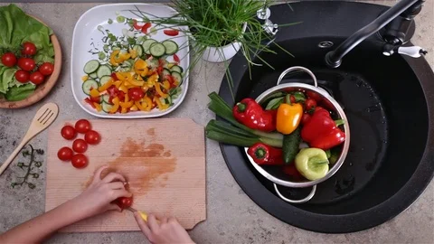 Child hands cutting cherry tomatoes for salad - top view Stock Footage 80114847