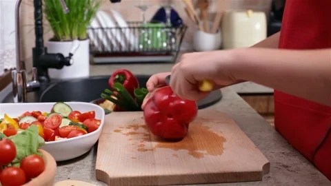 Child hands cutting a red bellpepper for a vegetables salad Stock Footage 80241832