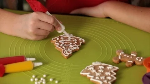 Child hands decorating gingerbread christmas cookies with sugar pearls Stock Footage 80299081