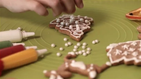 Child hands decorating gingerbread christmas cookies with sugar pearls Stock Footage 80299106