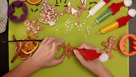 Child hands decorating a star shaped gingerbread christmas cookie Stock Footage 80328200