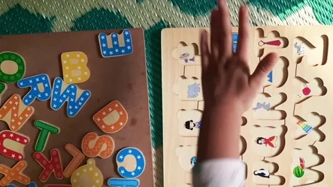 Child Hands Fitting Letter M into Wooden ABC Learning Board Stock Footage 340732059