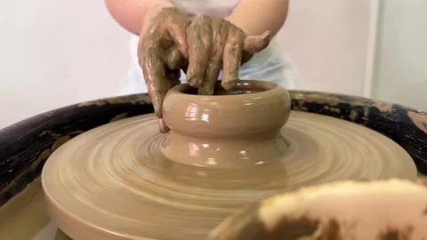 Child hands make earthenware cup working on pottery wheel at workshop. Stock Footage 307187467