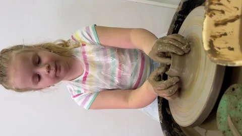 Child hands make earthenware cup working on pottery wheel at workshop. Stock Footage 307188499