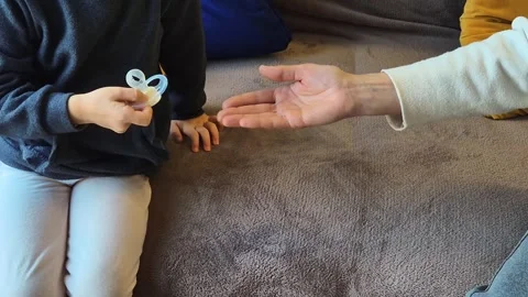 A child hands over a damaged pacifier to an adult 库存影片 301329867