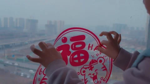 Child Hands Placing Red Chinese New Year Decal on Window Stock Footage 336547340