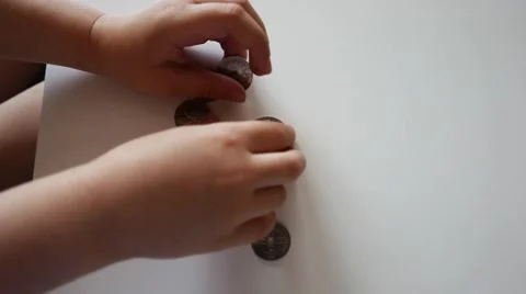 The child Hands play with coins on the table. Stock Footage 62551686