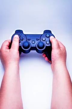 Child hands playing with the black remote of a console. Stock-Fotos