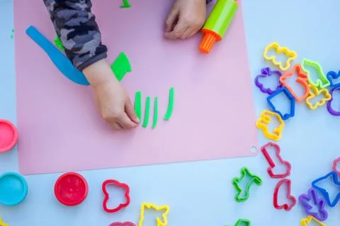 Child hands playing with plasticine Stock Photos