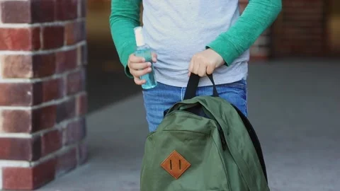 Child hands puts sanitizer in the school backpack protects from coronavirus Stock Footage 154251620