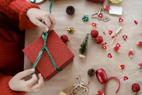 A child hands in red pullover opening red gift box closing Stock Photos