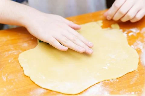 Child hands roll out thin dough Stock Photos