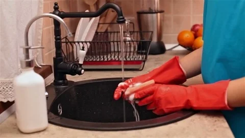 Child hands with rubber gloves preparing the sponge to wash dishes Stock Footage 80449178