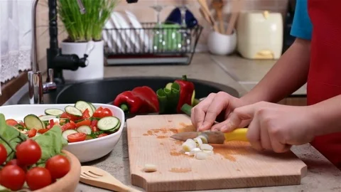 Child hands slicing spring onions for a vegetable salad Stock Footage 77679133