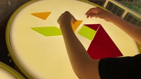 Child hands solving a colorful geometric tangram puzzle Stock Footage 345632812