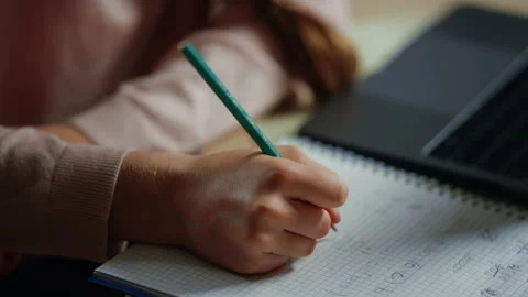 Child hands solving problems in notebook. Thoughtful girl studying at home. Stock Footage 142937526