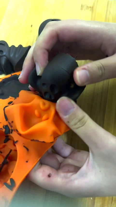 Child hands squeeze chocolate ghost out of soft silicone mold. Spooky candy Stock Footage 343478305
