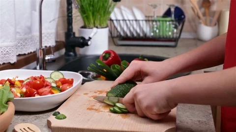 Child hands starts cutting a cucumber for a vegetables salad Stock Footage 80241849