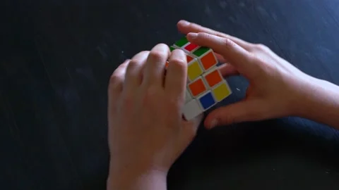 Child hands trying to solve Rubik's cube Stock Footage 136285545