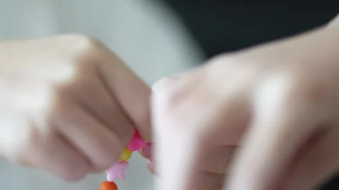Child Hands Tying Knot to Finish Colorful Bead Bracelet Video stock 334426422