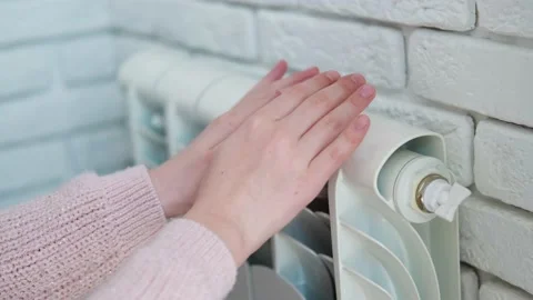 The child is hands warm their hands near the heating radiator. Stock Footage 195000810