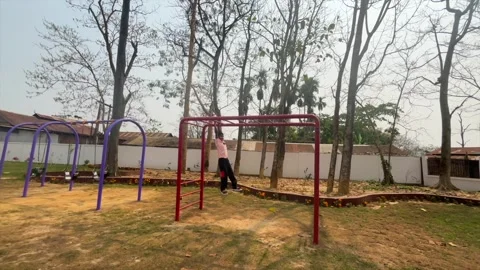 Child Hanging on Monkey Bars at Outdoor Playground in Dibrugarh 스톡 동영상 334774105