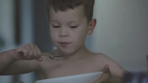 Child happily eats with spoon of carefree childhood and joy of nourishing meals Stock Footage 281883886