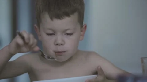 Child happily eats with spoon simple joy of childhood and savoring delicious kid Stock Footage 285794364