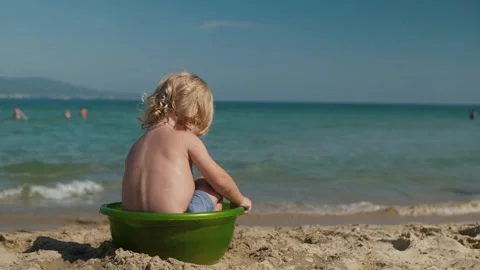 Child happily playing in basin at seaside Stock Footage 303497848