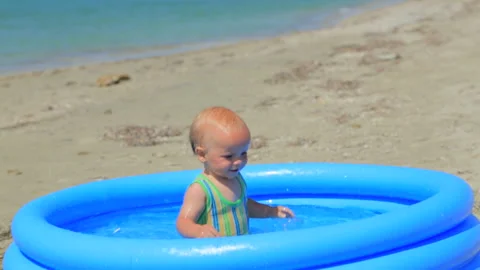 The child happily plays in the inflatable pool Stock-Footage 98481102