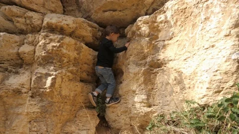 A child has fun climbing a wall in the Calanques National Park, in France Stock Footage 212487835