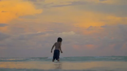 A child has fun falling in the turquoise water at sunset, in the Philippines Stock Footage 235485872