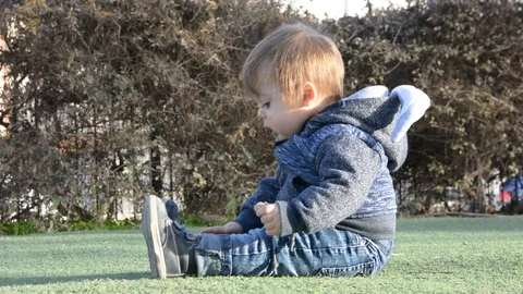 Child have fun on playground in park on sunny weekend day. Little Boy In A Playg 動画素材 102184064