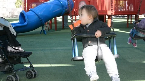 Child have fun on playground in park on sunny weekend day. Little Boy In A Playg 動画素材 102202955