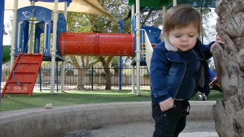 Child have fun on playground in park on sunny weekend day. Little Boy In A Playg 動画素材 104874820