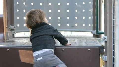 Child have fun on playground in park on sunny weekend day. Little Boy In A Playg Stock Footage 107628481